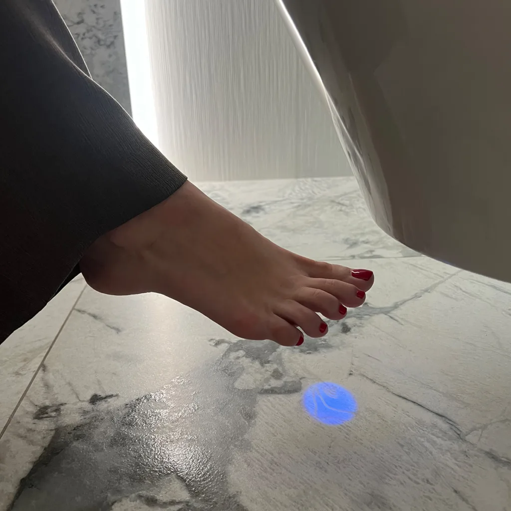 The Breeze illuminated foot sensor operated with a foot gesture