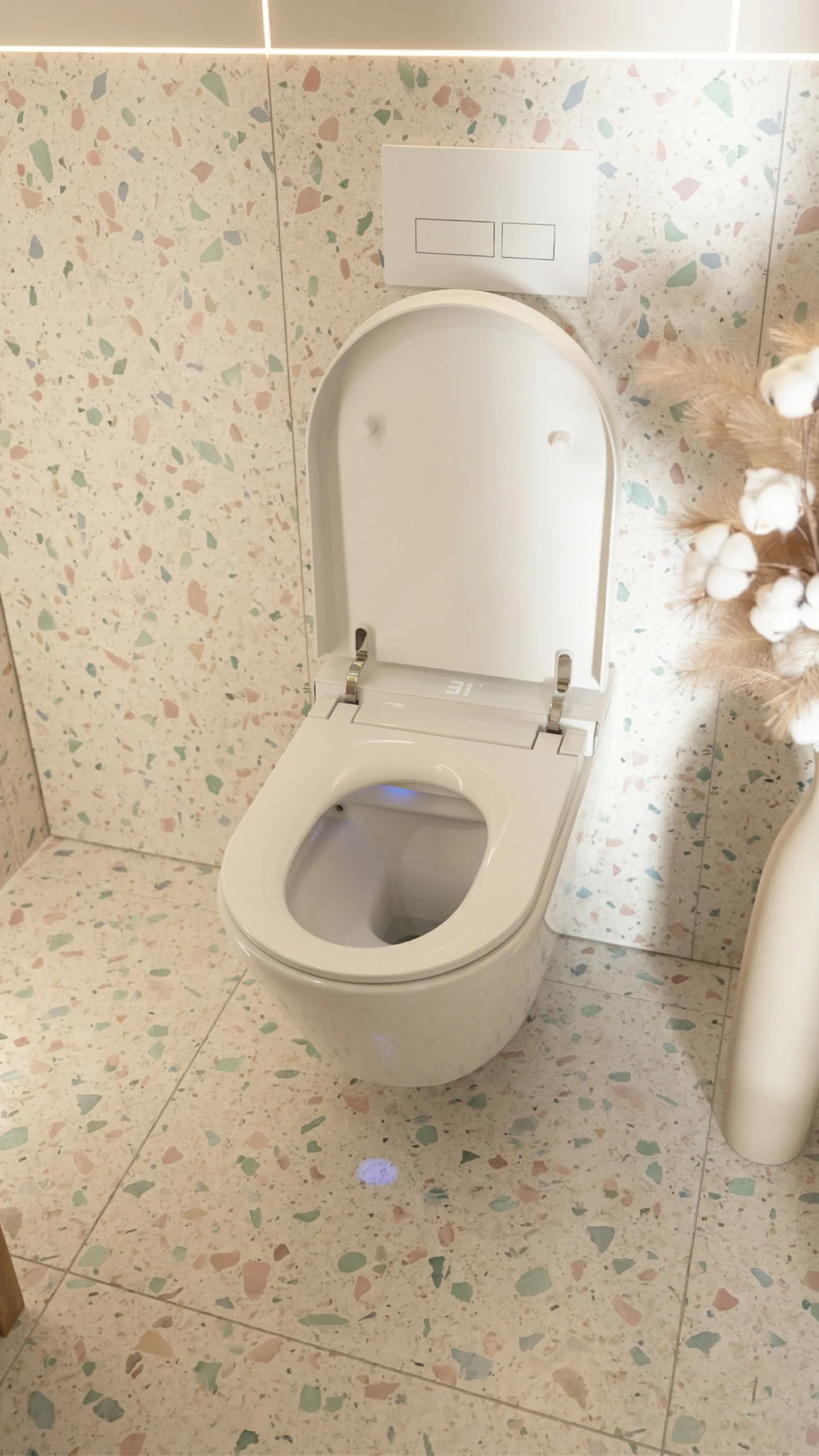 Breeze with open lid in a pale terrazzo bathroom